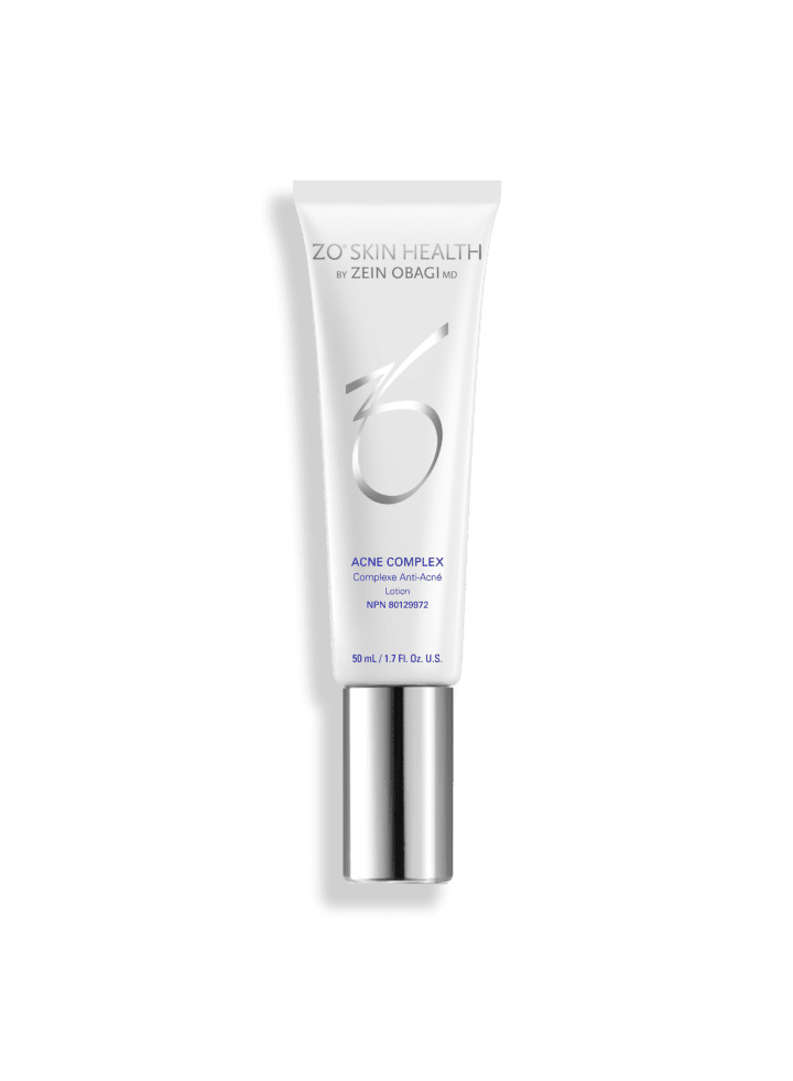Un tube de ZO Skin Health Acne Complex du Dr Zein Obagi. Son design épuré et minimaliste est un atout majeur de la Clinique médico-esthétique Viva. Tube blanc et argenté avec inscriptions bleues et grises, et bouchon vissé.